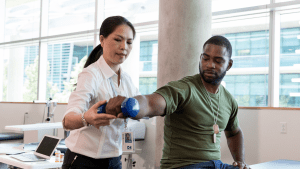 female physical therapist helping male with exercise
